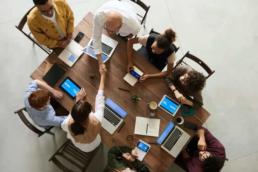Photo of a team at a table with laptops and tablets on it