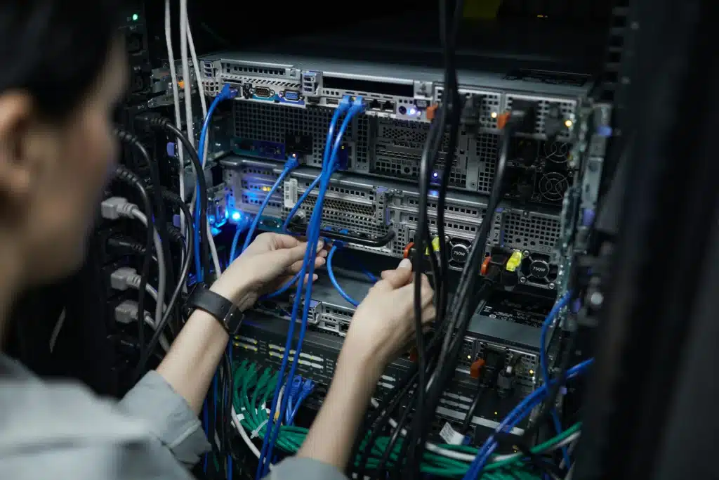 Photo of a person troubleshooting a column of routers with blue wires
