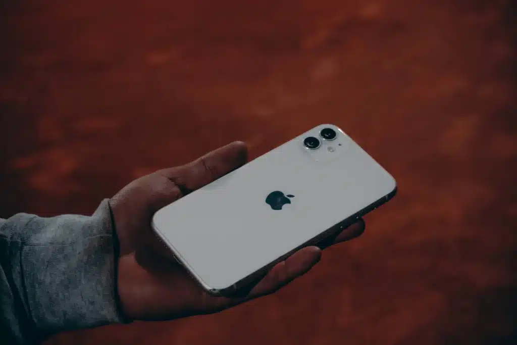 Man's hand holding white iPhone