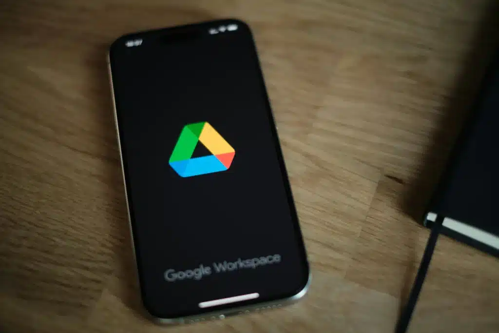 Google Workspace app open on iPhone lying on a wood table