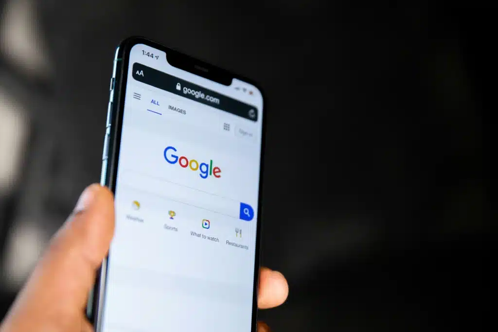 Hand holding iPhone with Google internet open