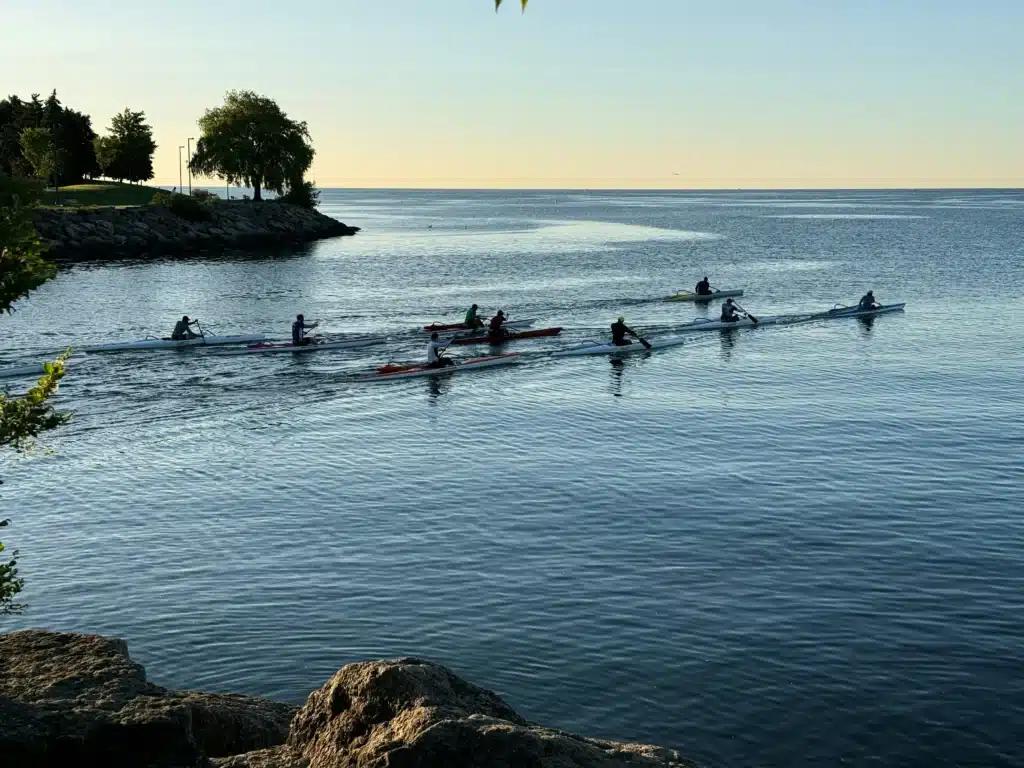 People canoeing on lake at sunset