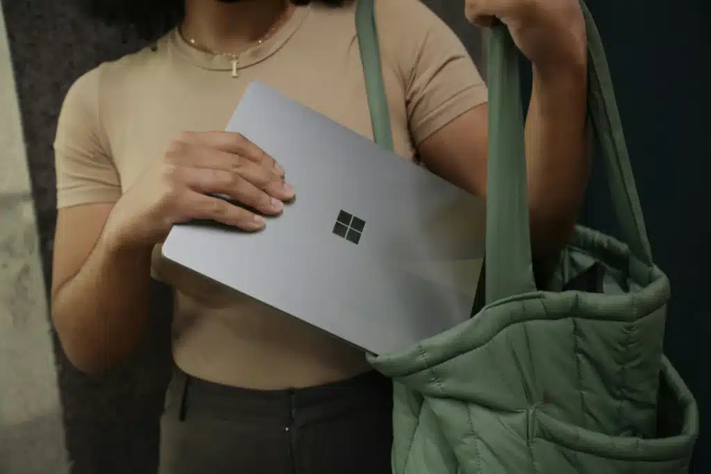 Woman putting Microsoft Surface into green tote bag