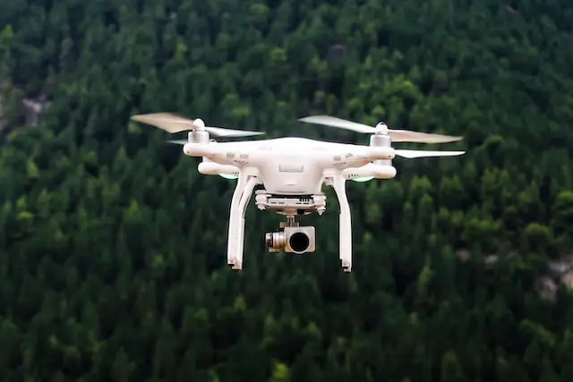 white drone flying over a field