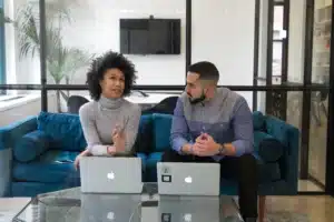 Man and woman sitting with Macbooks