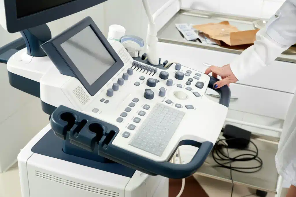 Woman's hand resting on white medical ultrasound device