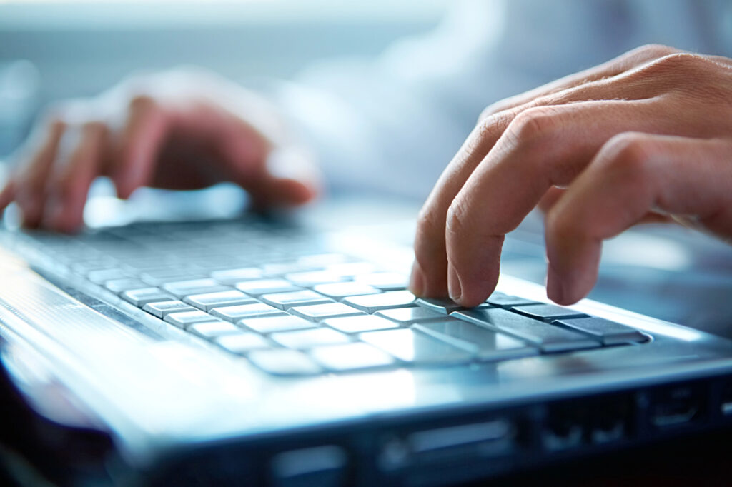 Close-up of hands typing on a laptop keyboard, representing IT infrastructure planning, business technology, and scalable digital systems for growing organizations.
